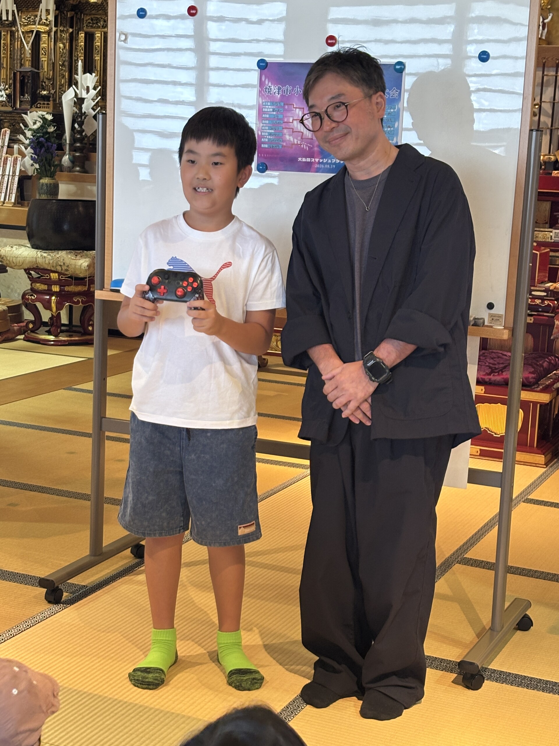 抽選景品を手に笑顔を見せる参加者