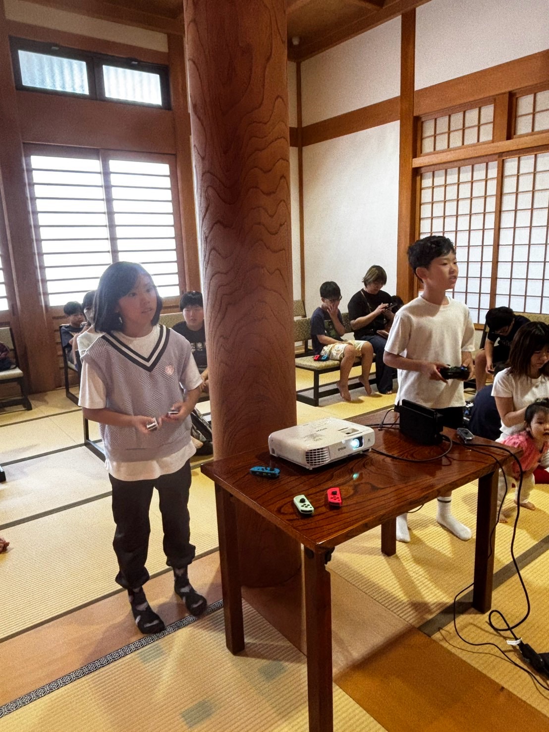 プロジェクターの前で対戦する参加者たち